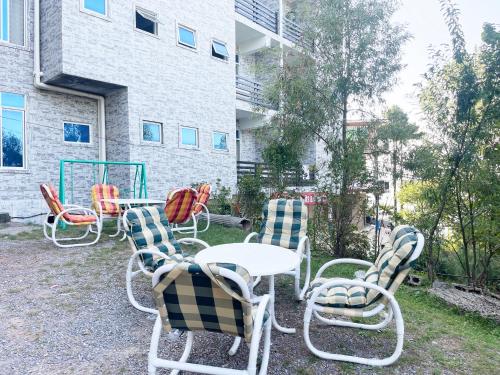 un grupo de sillas y mesas en un patio en Evergreen Apartment, en Murree