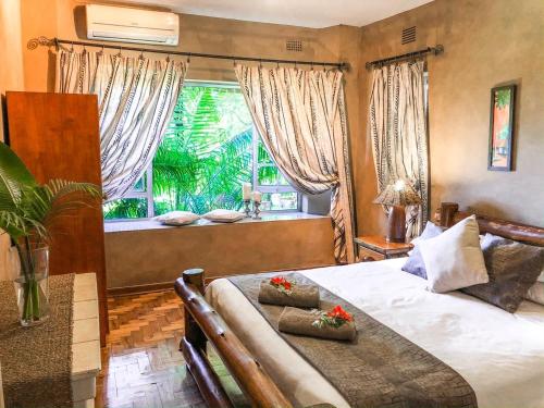 a bedroom with a bed and a large window at Ingwenya Lodge in St Lucia