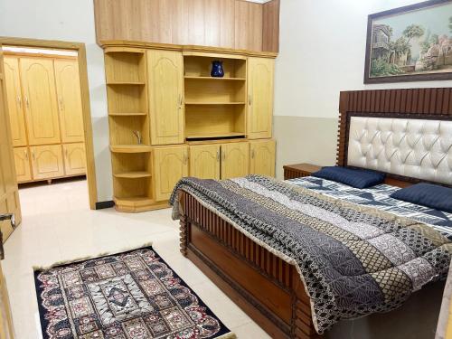 1 dormitorio con 1 cama y armario de madera en Evergreen Apartment, en Murree