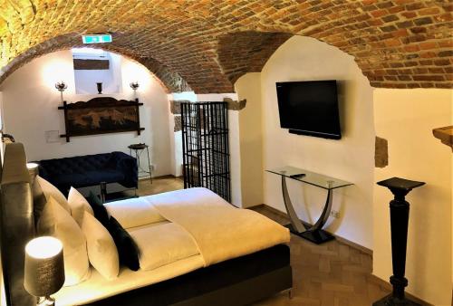 Historical Luxury Homes - Luxus Suite Colloseum في فريبورغ ام بريسغاو: غرفة نوم بسرير وتلفزيون في غرفة