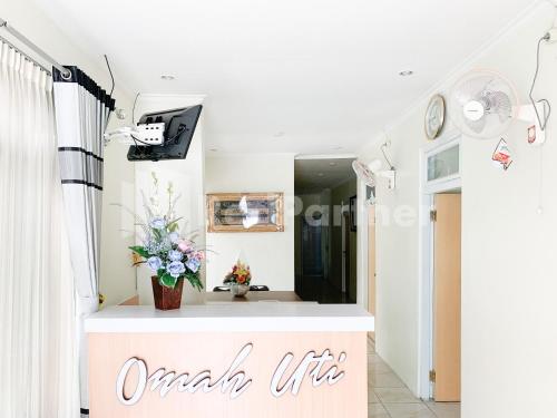 a living room with a table and flowers at Oma Uti Syariah Mitra RedDoorz near Stasiun Lempuyangan in Sentool