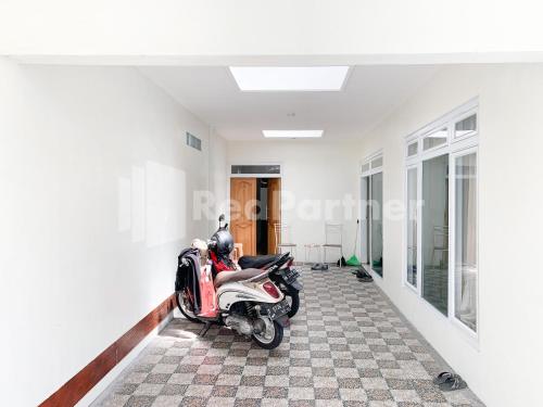 a motor scooter parked in a room at Oma Uti Syariah Mitra RedDoorz near Stasiun Lempuyangan in Sentool