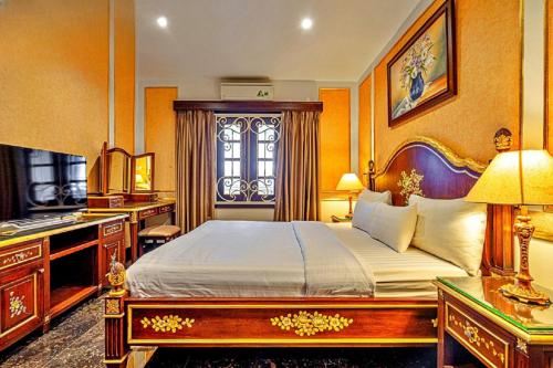 a bedroom with a bed and a desk and a television at 345AB Sai Gon Hotel in Ho Chi Minh City