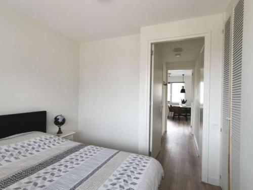 um quarto branco com uma cama e um corredor em Cornfield em Arnhem