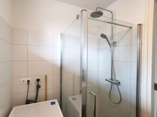 uma casa de banho com uma cabina de duche em vidro e um WC. em Cornfield em Arnhem