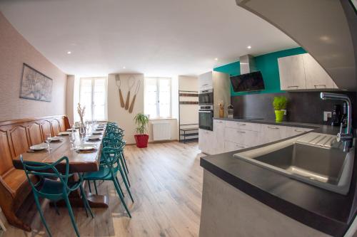 une cuisine et une salle à manger avec une table et des chaises vertes dans l'établissement Les clés de la ferme - 4 chambres - proche La Loupe et Nogent-le-Rotrou - option SPA, à Sablons-sur-Huisne