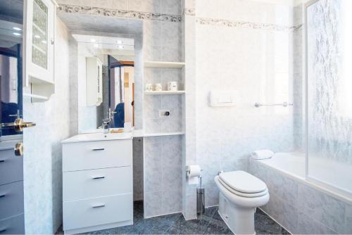 a bathroom with a toilet and a sink and a tub at Bright home in Milan