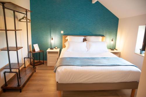 1 dormitorio con 1 cama grande y pared azul en Les clés de la ferme - 4 chambres - proche La Loupe et Nogent-le-Rotrou - option SPA, en Sablons-sur-Huisne