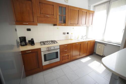 a kitchen with wooden cabinets and a stove top oven at Dolce Vita, garden, free parking in Turin