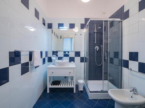 a blue and white bathroom with a sink and a shower at Youhosty - Via Savona 70 in Milan