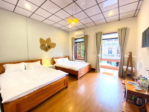 sypialnia z 2 łóżkami i oknem w obiekcie DH Homestay Cao Bằng w mieście Cao Bằng
