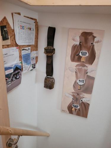 a wall with pictures of cows on it at Ferienhaus Gertrud in Nesselwängle
