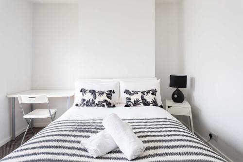1 dormitorio blanco con 1 cama con 2 almohadas en Belfast City - 3 Bed Cosy Terrace Home - Hip and Trendy Ormeau Road, en Belfast