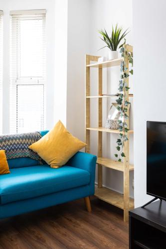 a blue couch in a living room with a tv at Belfast City - 3 Bed Cosy Terrace Home - Hip and Trendy Ormeau Road in Belfast