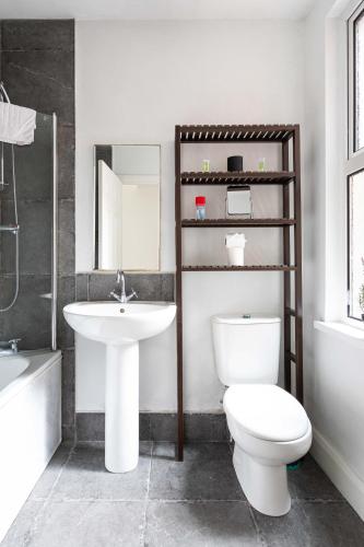 a bathroom with a toilet and a sink and a mirror at Belfast City - 3 Bed Cosy Terrace Home - Hip and Trendy Ormeau Road in Belfast