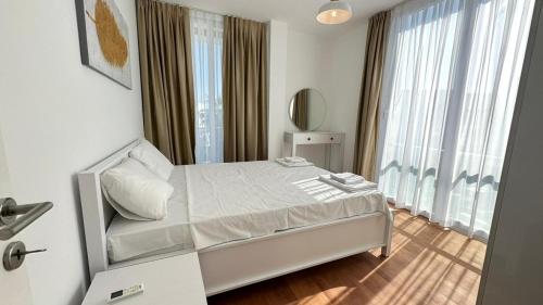 a white bedroom with a bed and a large window at Four Seasons Life Rentals in Trikomo