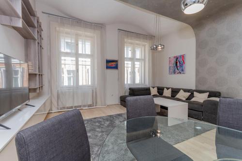 a living room with a couch and a glass table at Andrássy Str. Luxury Apartment in Budapest