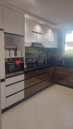 a kitchen with wooden cabinets and a stove top oven at Taghazout "luxe residence Tafoult" 3 pools and aquapark in Taghazout