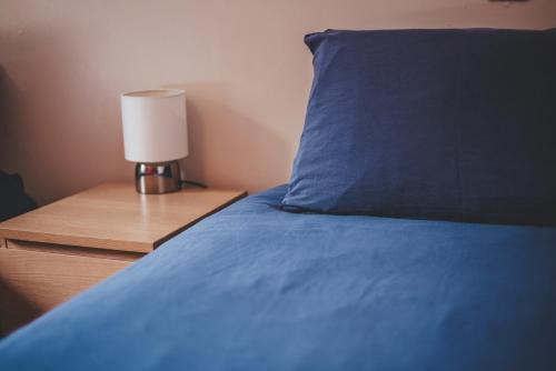 a bed with a blue pillow and a lamp on a night stand at Oban Youth Hostel in Oban