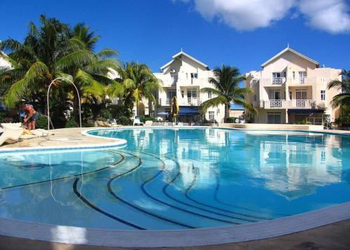 una gran piscina en un complejo con palmeras en Villacool - Lot No 25 Residence Le Tamier, en Flic en Flac