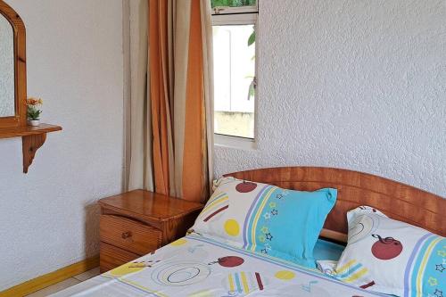 1 cama con 2 almohadas y una ventana en una habitación en Villacool - Lot No 25 Residence Le Tamier, en Flic en Flac