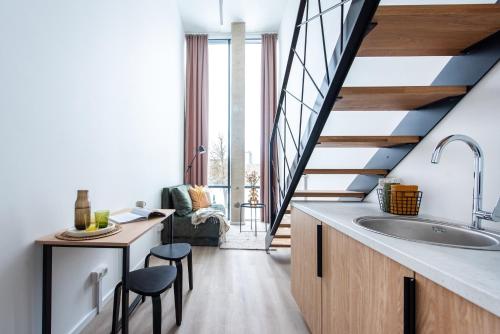 a kitchen with a large sink and a staircase at We LOFT in Vilnius