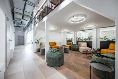a living room with couches and chairs and tables at We LOFT in Vilnius