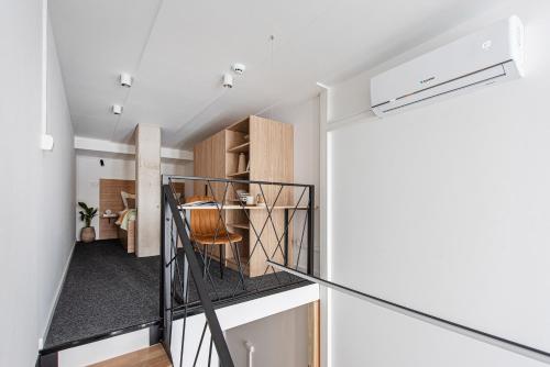 a room with a staircase leading to a kitchen and a living room at We LOFT in Vilnius