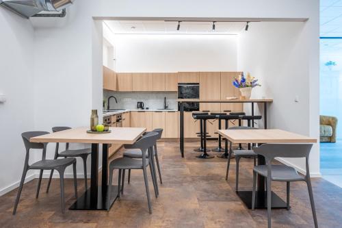 a kitchen and dining room with tables and chairs at We LOFT in Vilnius