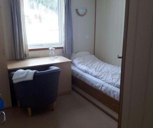 a room with a bed and a chair and a window at FjellRo 