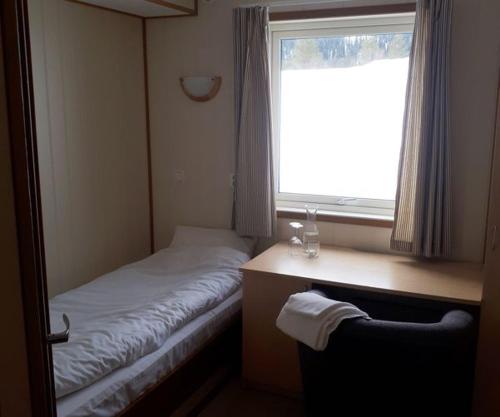 a small room with a bed and a window at FjellRo 