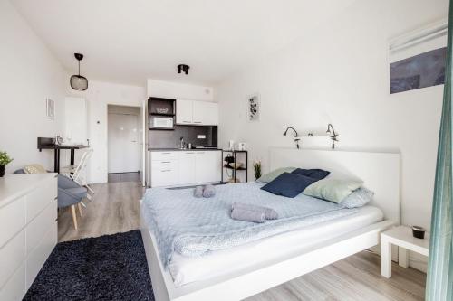 ein weißes Schlafzimmer mit einem großen Bett und einer Küche in der Unterkunft Modern Riverside Studio with Free Parking in Budapest