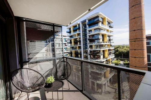 a balcony with two chairs and a building at Modern Riverside Studio with Free Parking in Budapest