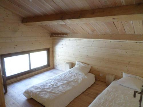 a room with two beds in a log cabin at Gte T3 Le Balarino - Mercantour1 in Belvédère