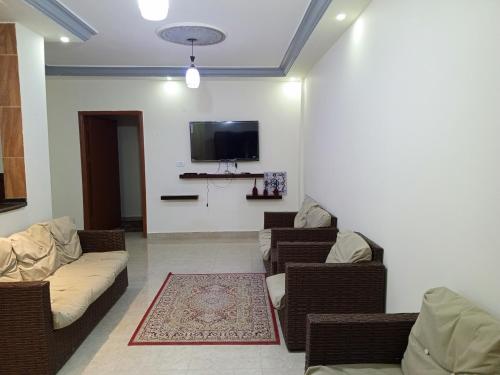 ein Wohnzimmer mit Sofas und einem Flachbild-TV in der Unterkunft Petra Inn House in Wadi Musa
