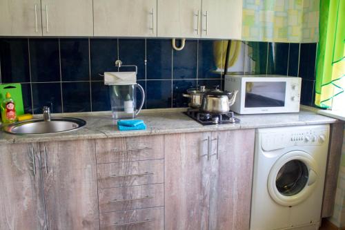 a kitchen counter with a sink and a microwave at Рэдиссон in Petropavlovsk