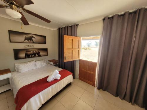 a bedroom with a bed with a stuffed animal on it at Jackalberry Guest Farm in Parys
