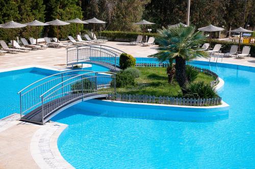 a swimming pool with a bridge in a resort at Alexandros Palace in Ouranoupoli