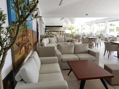 a restaurant with white couches and tables at Alexandros Palace in Ouranoupoli