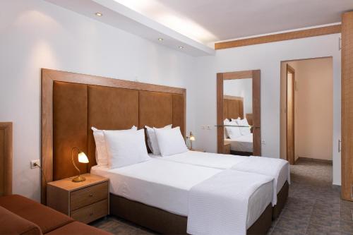 a bedroom with a large white bed and a couch at Alexandros Palace in Ouranoupoli