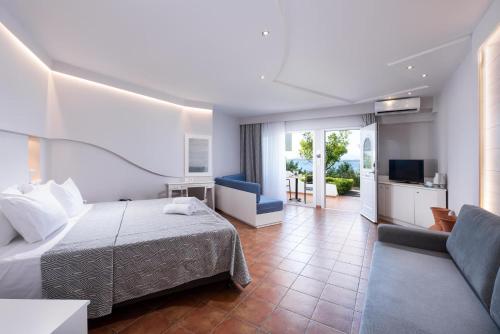 a hotel room with a bed and a living room at Alexandros Palace in Ouranoupoli