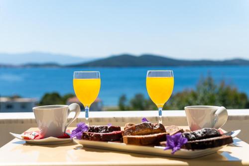 a table with two glasses of orange juice and toast at Alexandros Palace in Ouranoupoli