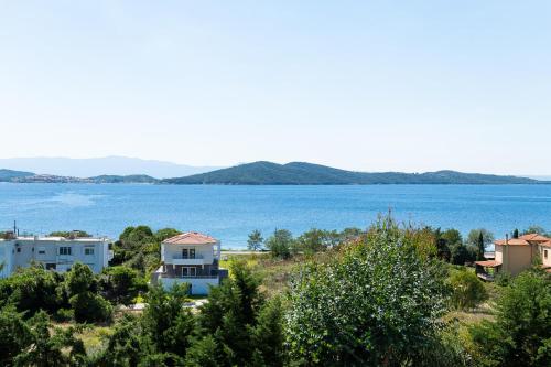 a view of a large body of water with houses at Alexandros Palace in Ouranoupoli
