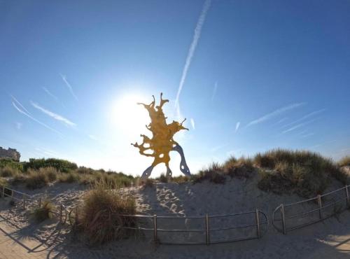 a statue of a tree on top of a beach at Studio Abee in Middelkerke