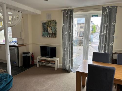 a living room with a dining table and a television at Trotters Place - Bradwell in Bradwell