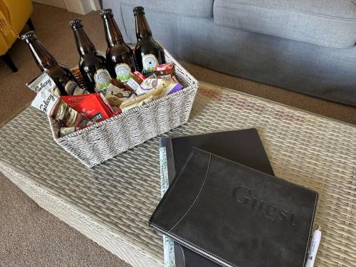 a basket of beer on a table next to a book at Trotters Place - Bradwell in Bradwell