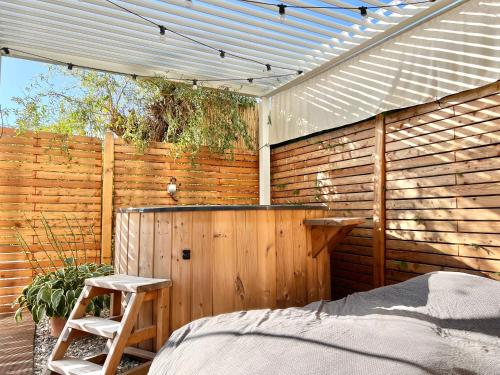 a wooden privacy fence with a bed and a ladder at Tiny House Gänseblümchen in Kirchanschöring