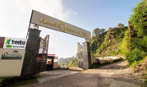 a sign for a hotel on the side of a road at Treebo Tryst Queen Of Hills Near Mall Road in Mussoorie
