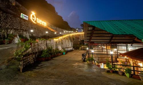 a building with lights on the side of it at night at Treebo Tryst Queen Of Hills Near Mall Road in Mussoorie