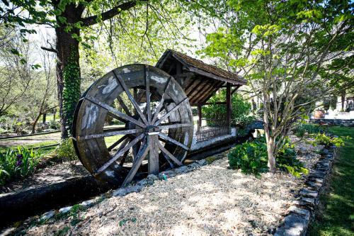 a wooden wagon wheel sitting in a garden at Lodge ou Gîte de caractére avec jaccuzi spa piscine in Argelès-Gazost